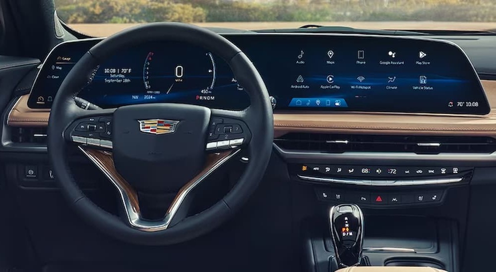 The tan and black interior and dash of a 2024 Cadillac XT4 is shown.
