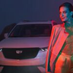 A white 2024 Cadillac XT6 for sale is shown parked near a person.