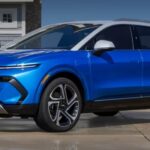 A blue 2023 Chevy Equinox EV is shown parked near a beach after competing in a 2024 Chevy Blazer EV vs 2024 Chevy Equinox EV comparison.