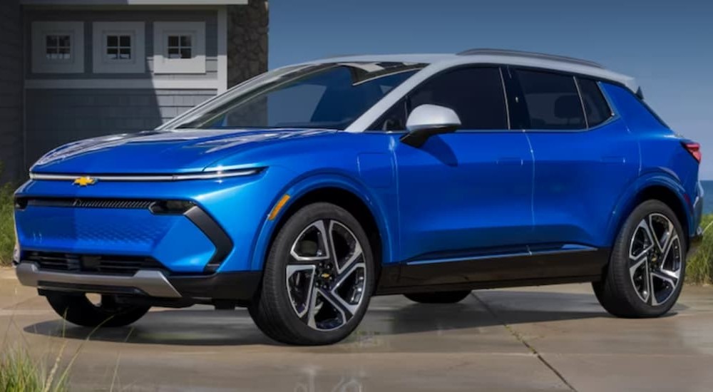A blue 2023 Chevy Equinox EV is shown parked near a beach after competing in a 2024 Chevy Blazer EV vs 2024 Chevy Equinox EV comparison.