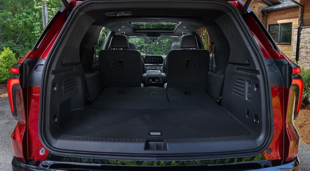 The black cargo area of a red 2024 Chevy Traverse.