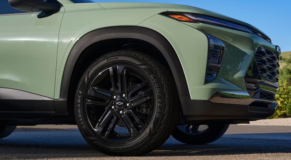 The front passenger side tire of a green 2024 Chevy Trax is shown.