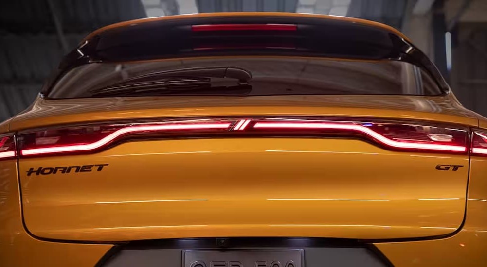 The taillights of a yellow 2024 Dodge Hornet is shown from the rear.