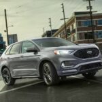 A 2024 Ford Edge St is shown driving on a city street.