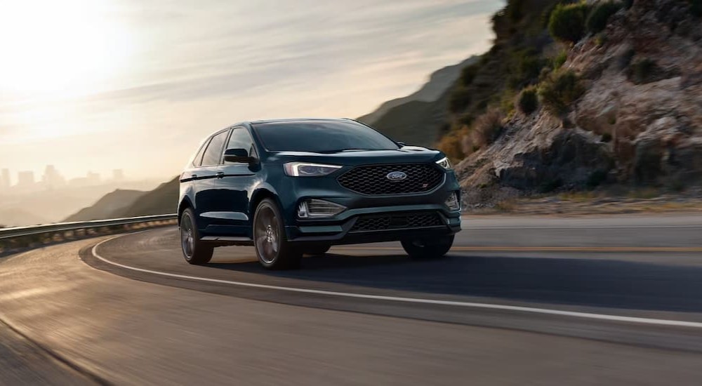 A green 2024 Ford Edge ST is shown driving on a highway.