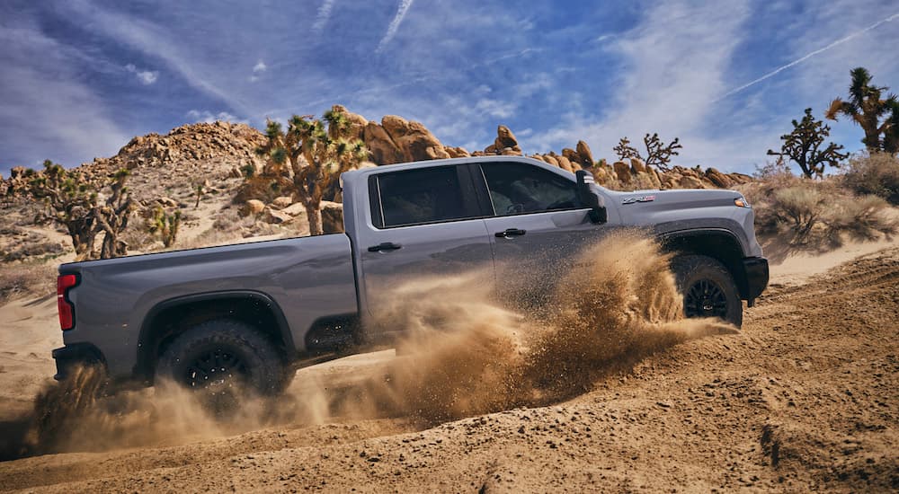 A red 2024 Chevy Silverado 2500 HD ZR2 is shown from the side while off-road.