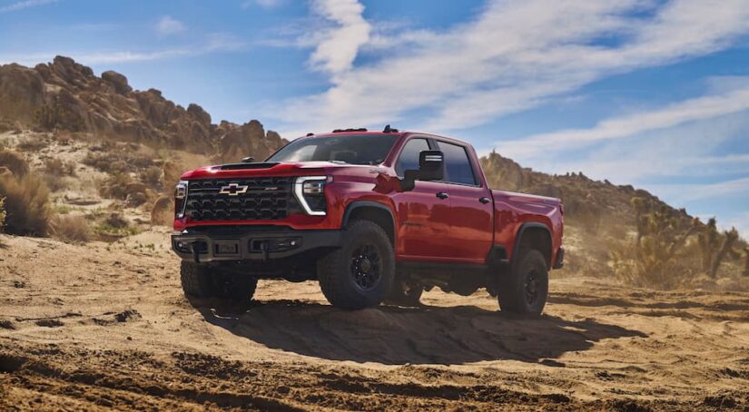 A red 2024 Chevy Silverado 2500 HD ZR2 Bison is shown from the front at and angle while off-road.