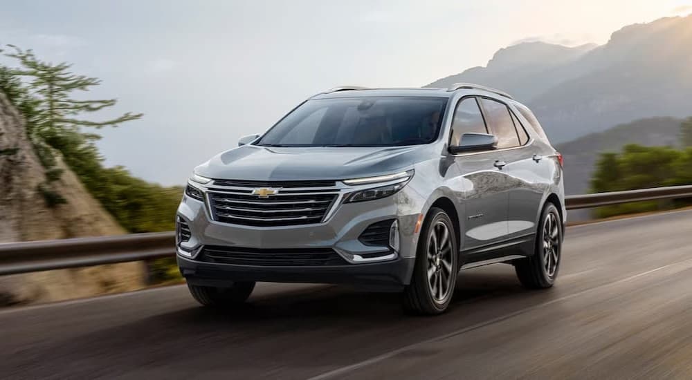 A silver 2024 Chevy Equinox LS is shown driving on a highway.