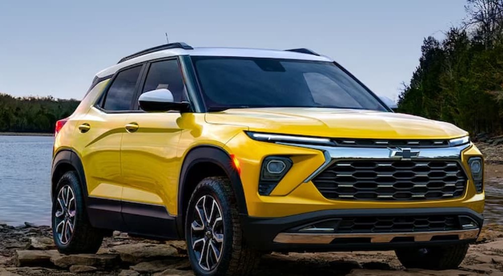 A yellow 2024 Chevy Trailblazer is shown parked near water.