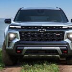 A silver 2024 Chevy Traverse Z71 is shown driving.