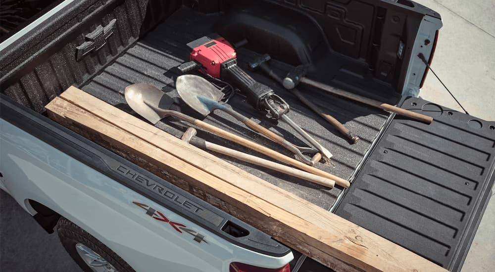 A set of tools are shown in the bed of a white 2023 Chevy Silverado 1500 WT at a Chevy truck dealer.