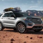 A silver 2023 Ford Explorer for sale is shown parked on dirt.