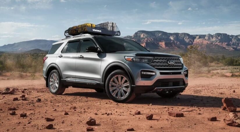 A silver 2023 Ford Explorer for sale is shown parked on dirt.