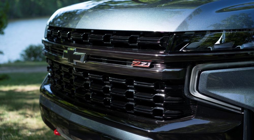 A close-up on the grille of a silver 2022 Chevy Suburban Z71 is shown.