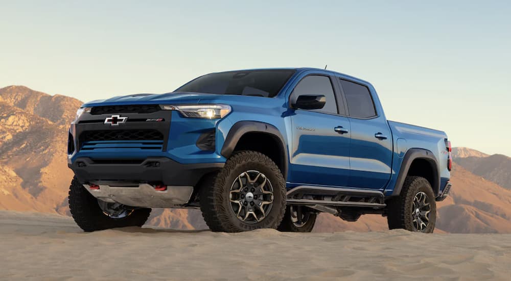 A blue 2023 Chevy Colorado ZR2 is shown parked off-road in a desert.