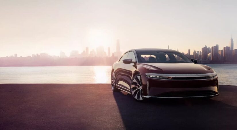 A purple 2023 Lucid Air is shown parked near a city after viewing EVs for sale.