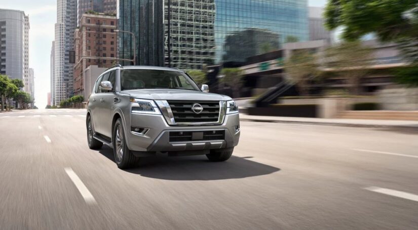 A silver 2023 Nissan Armada is shown driving on a city street.