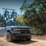 A popular Ford Bronco Sport for sale, a blue 2024 Ford Bronco Sport Outer Banks, is shown driving off-road.