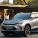 A silver 2024 Chevy Blazer is shown parked near a house.