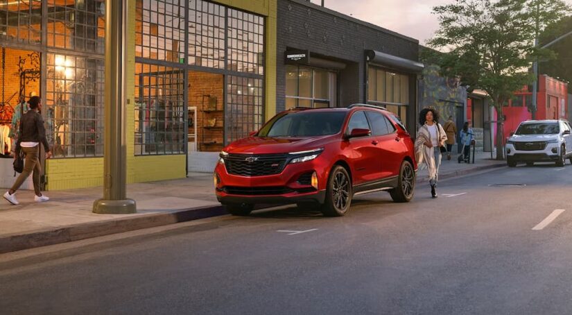 A red 2024 Chevy Equinox EV is shown parked on a city street.