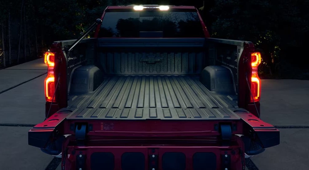 The open truck bed of a red 2024 Chevy Silverado 1500 is shown.