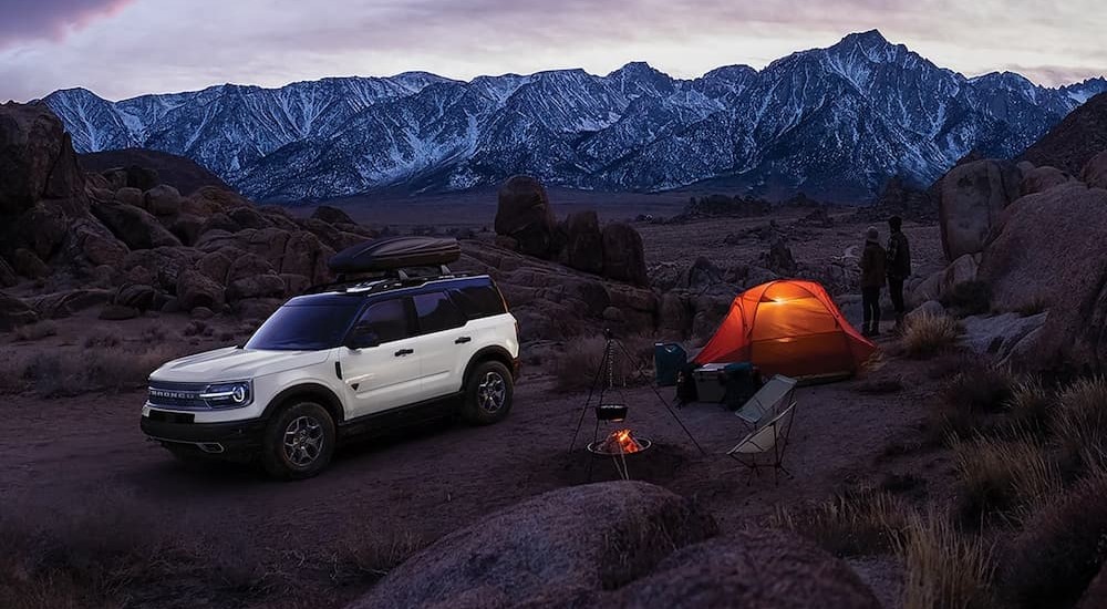 A white 2024 Ford Bronco Sport Badlands is shown parked on a camping site.