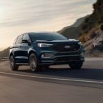 A black 2024 Ford Edge for sale is shown driving.