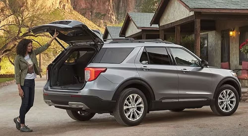A silver 2024 Ford Explorer is shown parked near a cabin.