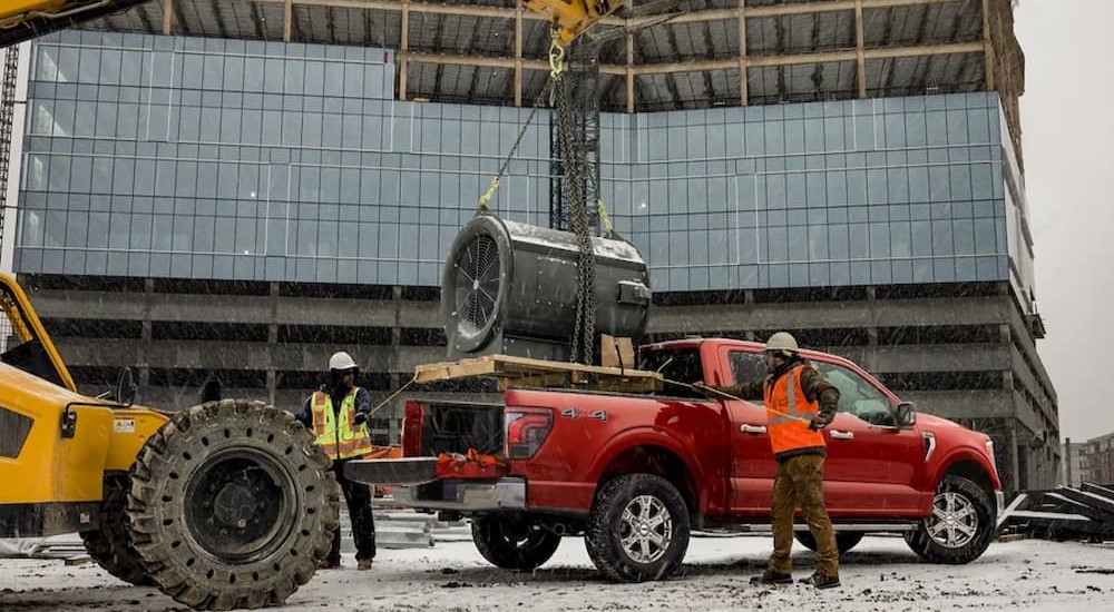 A red 2024 Ford F-150 is shown parked on a construction site.