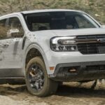 A white 2024 Ford Maverick is shown driving through mud.