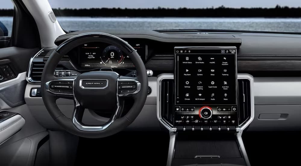 The black and gray interior and dash of a 2024 GMC Acadia is shown.