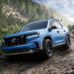 A popular Honda Pilot for sale, a blue 2024 Honda Pilot, is shown driving off-road.