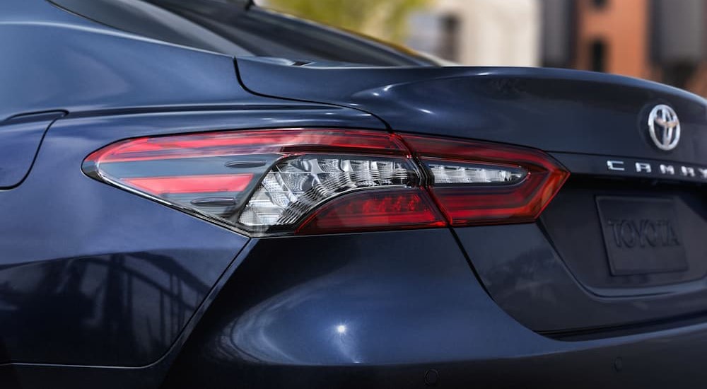A close-up of a rear taillight on a blue 2024 Toyota Camry XLE is shown.