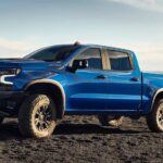 A blue 2024 Chevy Silverado 1500 ZR2 is shown parked off-road in a desert after winning the 2024 Chevy Silverado 1500 vs 2024 RAM 1500 competition.