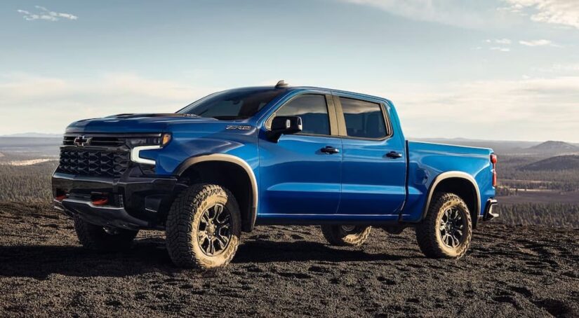 A blue 2024 Chevy Silverado 1500 ZR2 is shown parked off-road in a desert after winning the 2024 Chevy Silverado 1500 vs 2024 RAM 1500 competition.