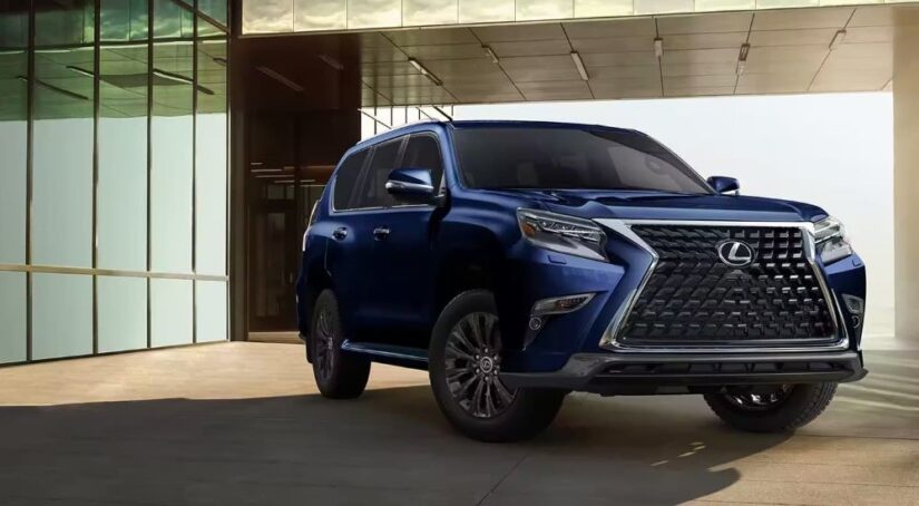 A blue 2023 Lexus GX for sale is shown in front of a modern building.