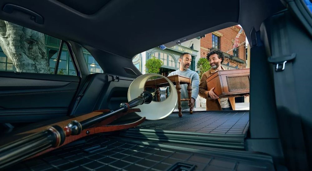 People are shown loading furniture into a 2024 Volkswagen Atlas Cross Sport.