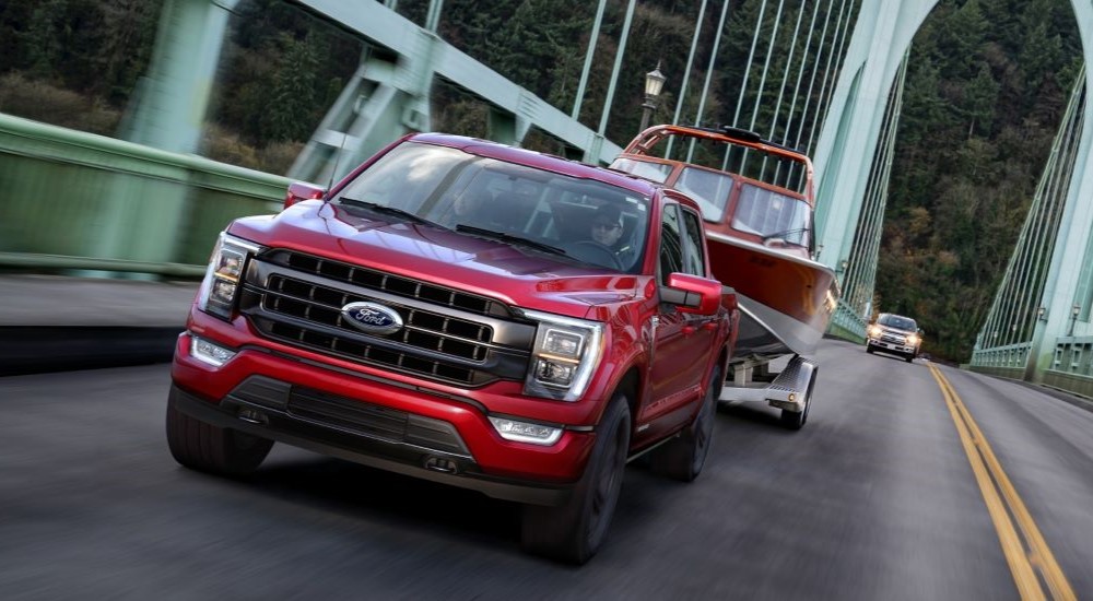 A red 2021 Ford F-150 is shown driving on a bridge.