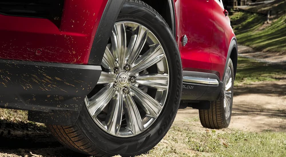 A close-up on the wheel of a red 2023 Ford Explorer King Ranch is shown.
