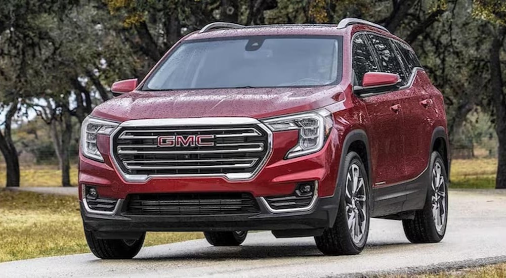 A red 2023 GMC Terrain is shown driving on road.