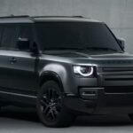 A gray 2023 Land Rover Defender 130 is shown parked on a cement floor.