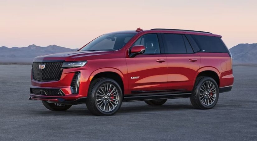 A red 2024 Cadillac Escalade for sale is shown parked off-road.