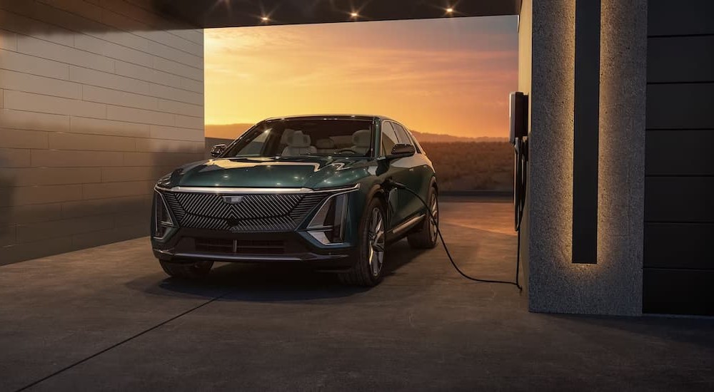 A green 2024 Cadillac Lyriq is shown parked and charging.