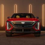 A red 2024 Cadillac Lyriq for sale is shown parked in a showroom.