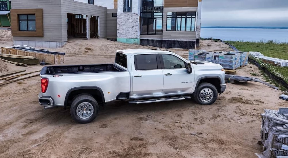 A white 2024 Chevy Silverado 3500 HD High Country is shown parked on a construction site.