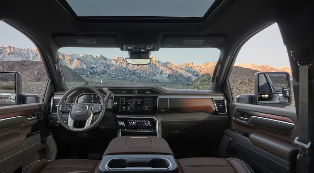 The gray and brown interior and dash of a 2024 GMC Sierra 2500HD is shown.