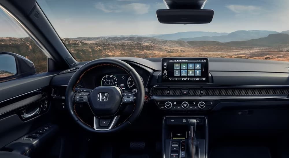 The black interior and dash of a 2024 Honda CR-V ST Hybrid is shown.