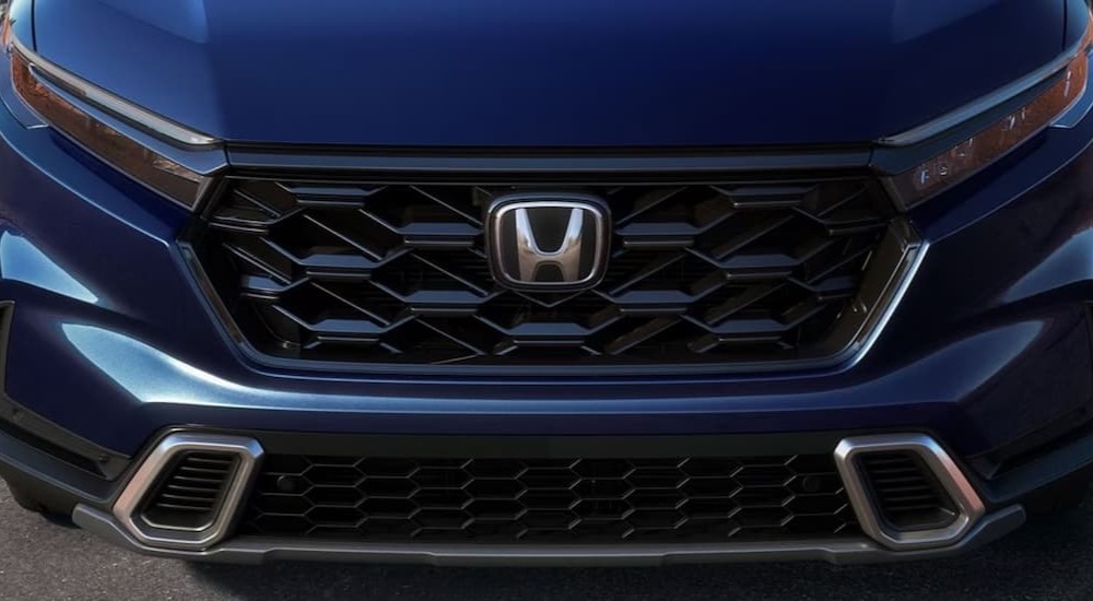 The close-up of the grille on a blue 2024 Honda CR-V Hybrid is shown.
