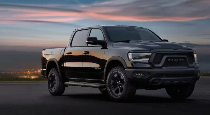 A black 2024 Ram 1500 for sale is shown parked at night.