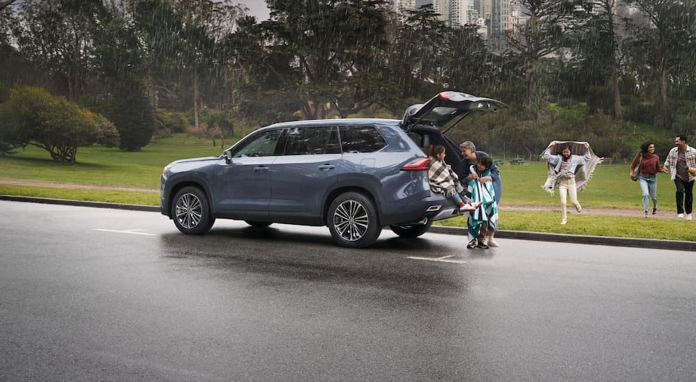 a blue 2024 Toyota Grand Highlander is shown parked on a rainy day.